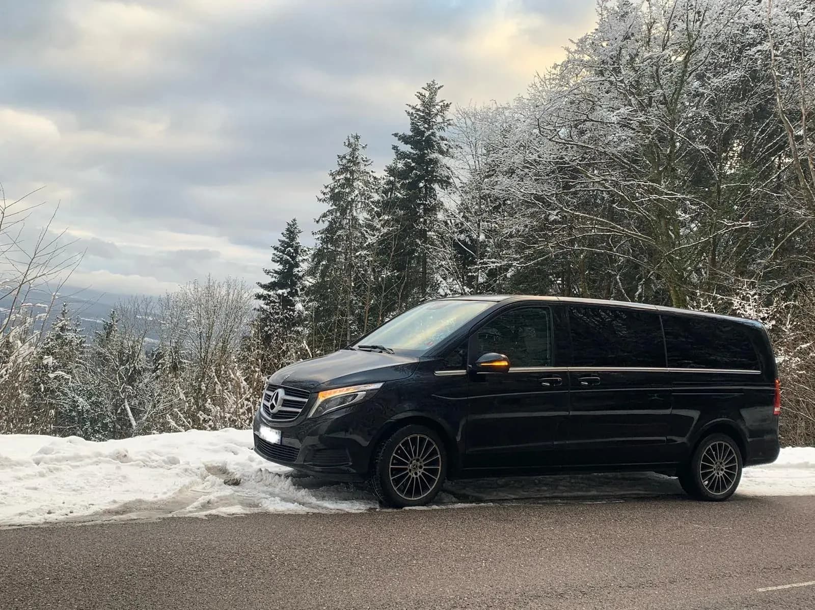 Zwarte Mercedes V-Klasse, privé shuttle naar Europa-Park, winters Zwarte Woud landschap